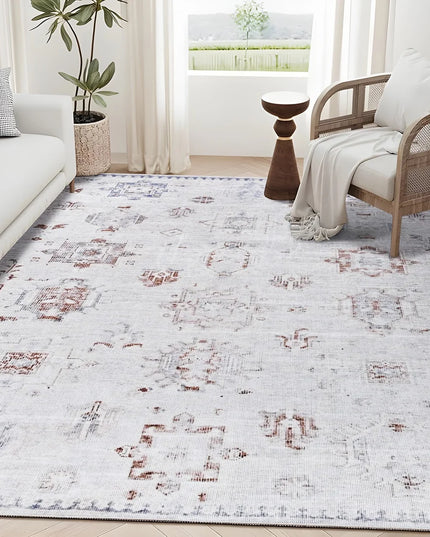 Living room with a patterned rug, sofa, armchair, and decorative plants.