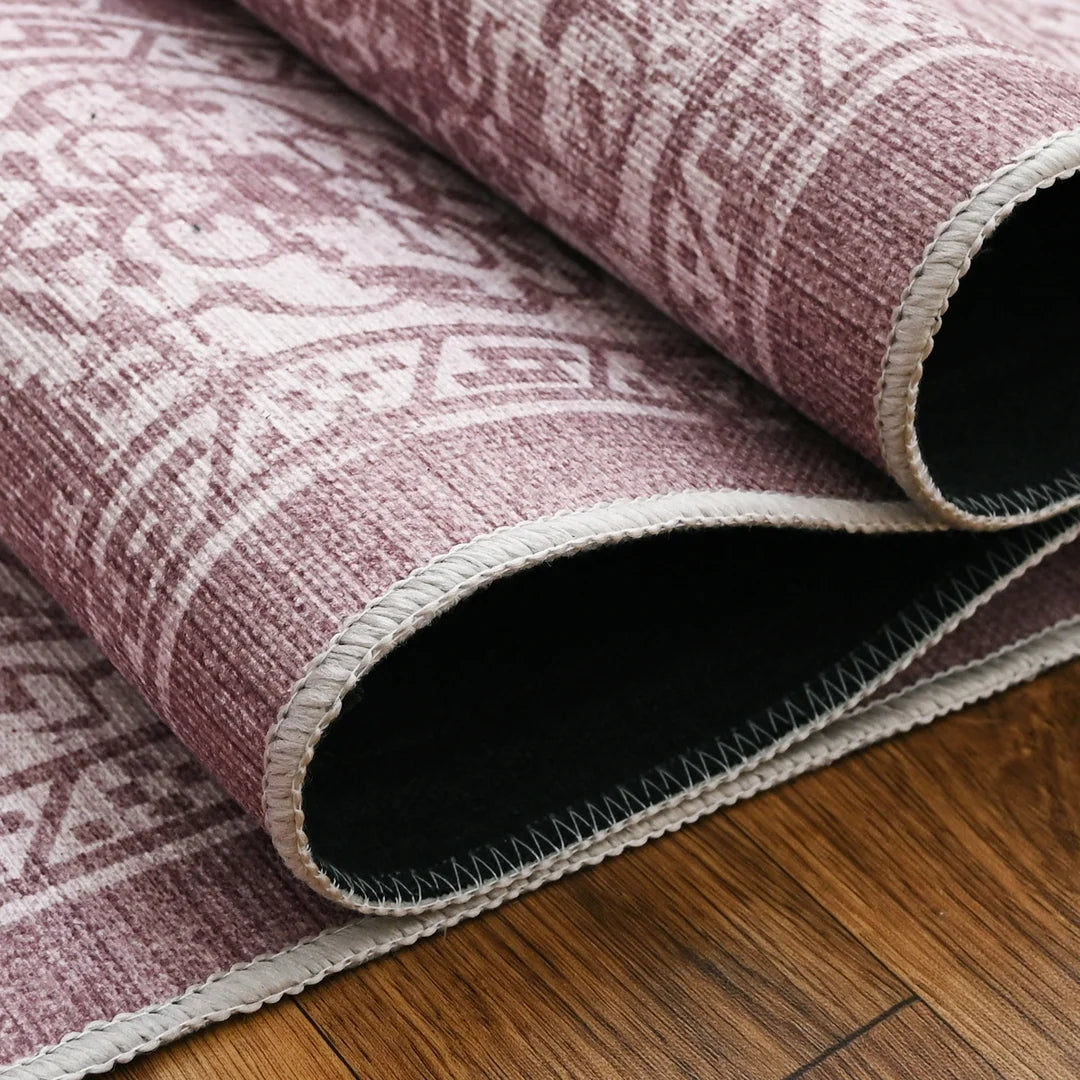 Roll of pink patterned rug on a wooden floor