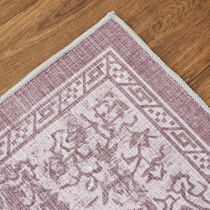 Close-up of a pink and white patterned rug on a wooden floor