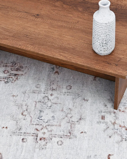 Wooden coffee table with a textured white vase on a patterned rug