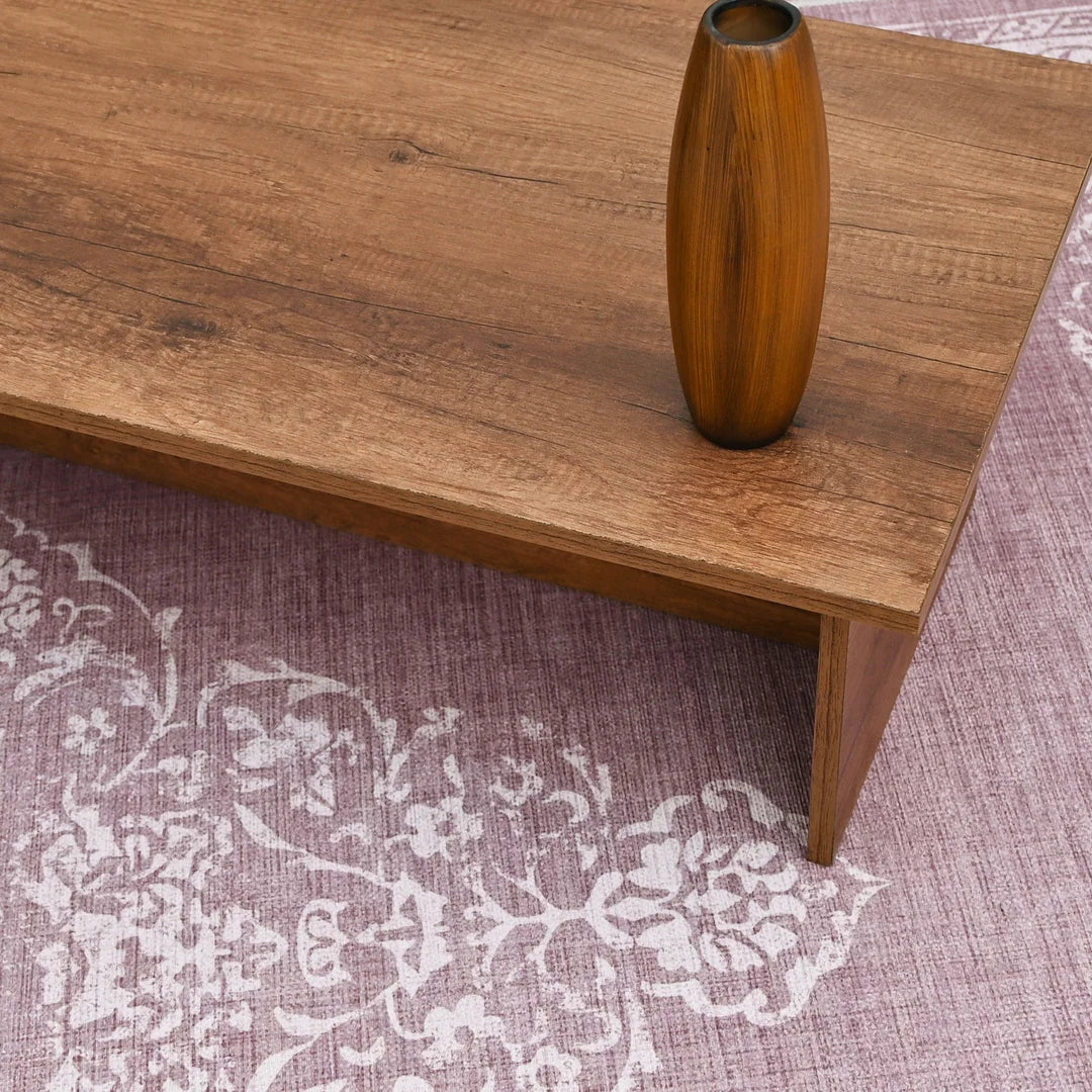 Wooden table with a vase on a patterned rug