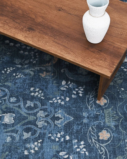 Wooden table with a white vase on a blue patterned rug