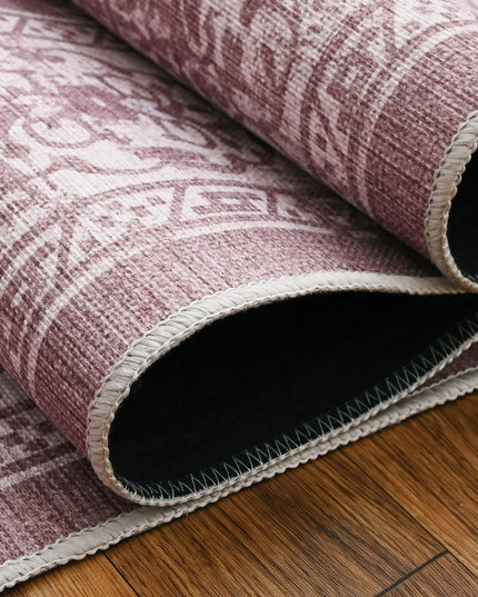 Roll of pink patterned rug on a wooden floor